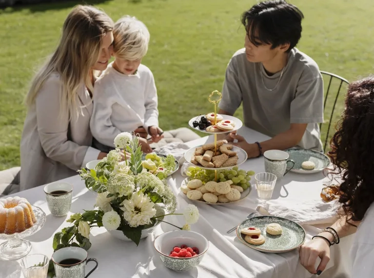 En grupp människor som sitter runt ett bord med mat.