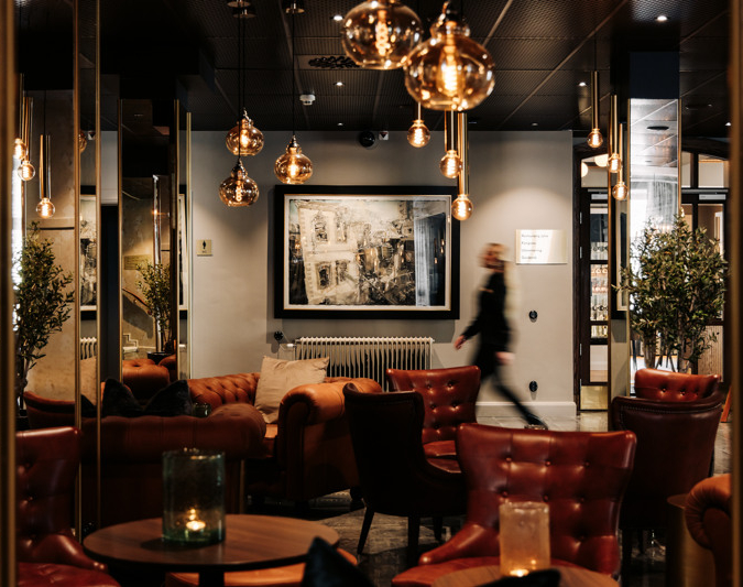 Kvinna passerar en tavla av Lars Lerin på Skara Stadshotell