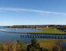 Ett vattendrag omgiven av ett grönskande fält med Vänersborg i bakgrunden.