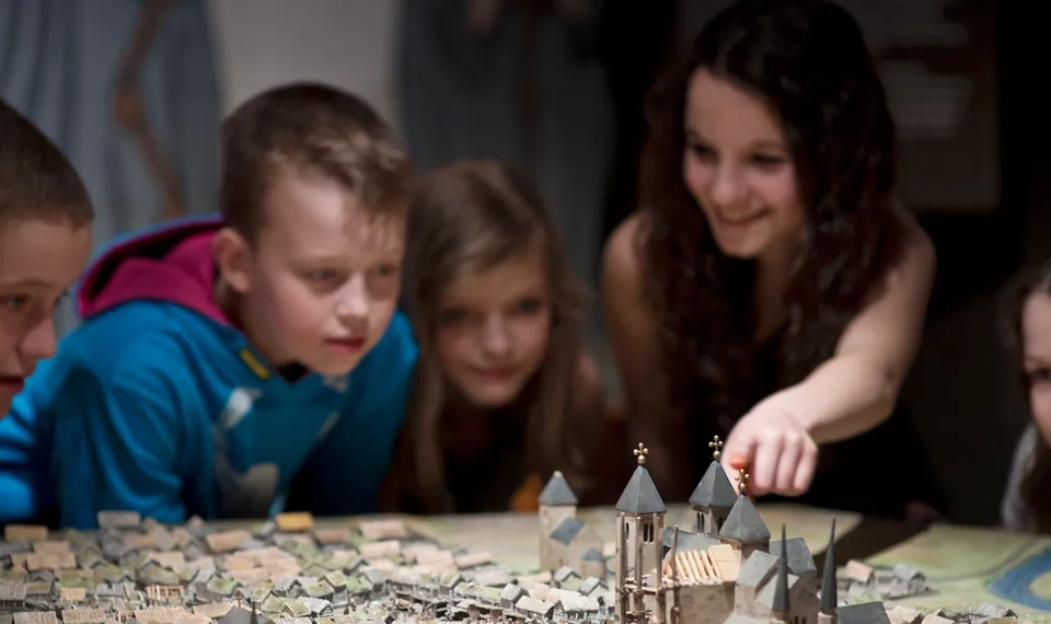 Barn tittar på modell av medeltiden i Skara på Västergötlands museum
