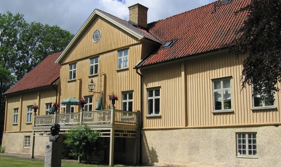 Ett stort gult hus med rött tak.