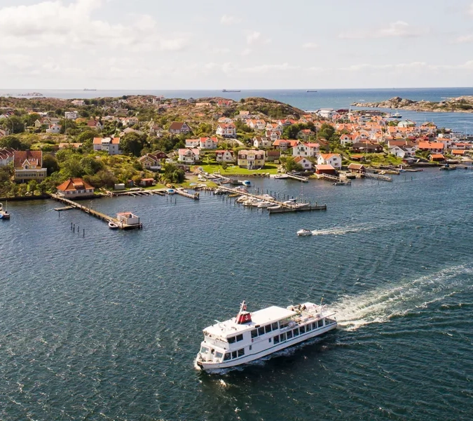 En båt som färdas längs en flod intill en liten stad.