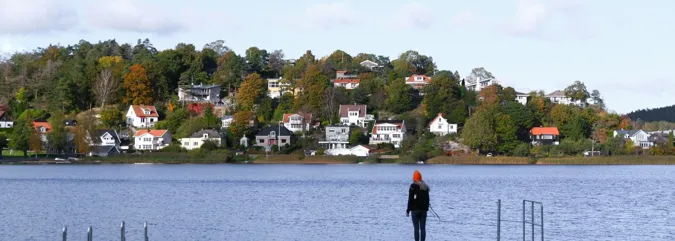A person standing on a dock in the middle of a lake.