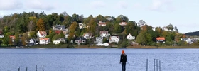 A person standing on a dock in the middle of a lake.