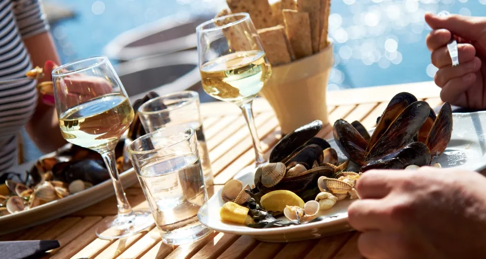 A couple of people sitting at a table with plates of food.