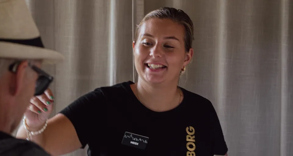 En kvinna står vid en disk och pratar med en man.