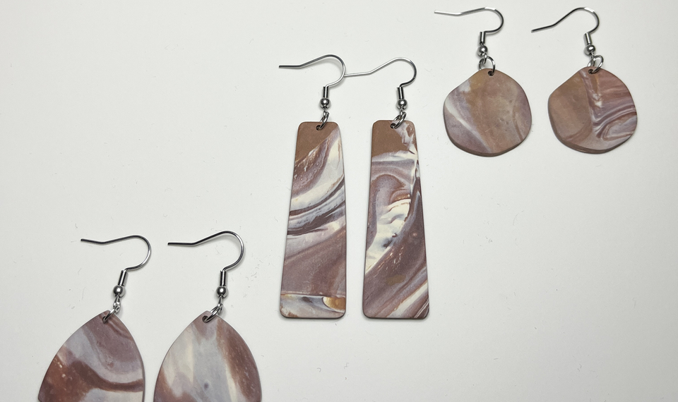 En uppsättning av tre örhängen med olika former.