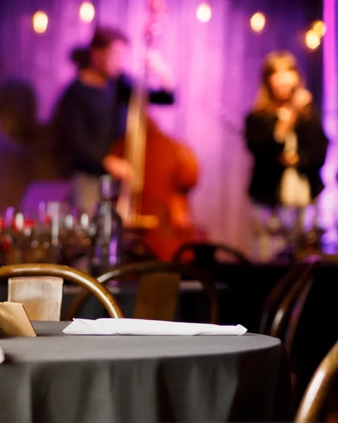 Musiklokal med scen och dukade bord.