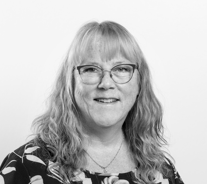 A black and white photo of a woman with glasses.
