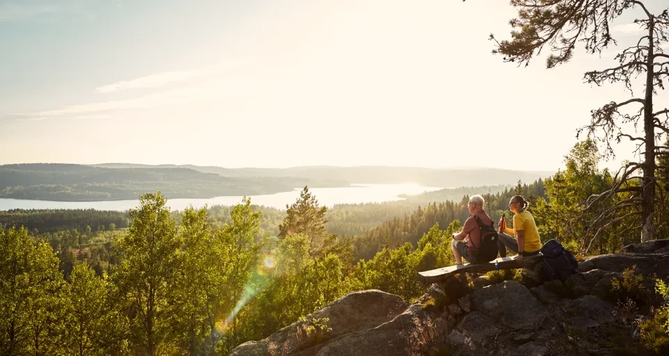 A couple of people sitting on top of a mountain.