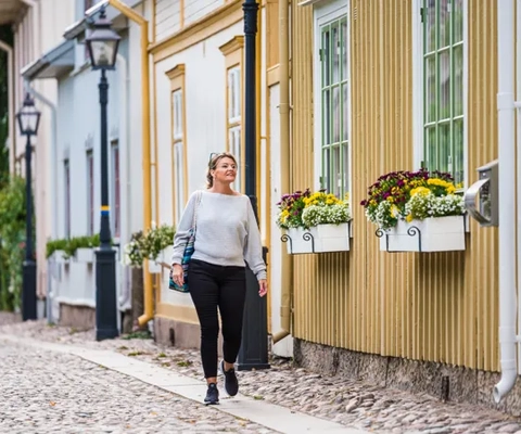 Kvinna promenerar i trästaden Hjo