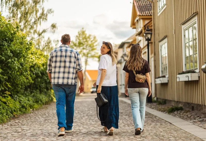 A group of people walking down a cobblestone road.