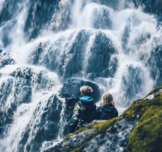 Två personer som tittar på vattenfallet Brudslöjan