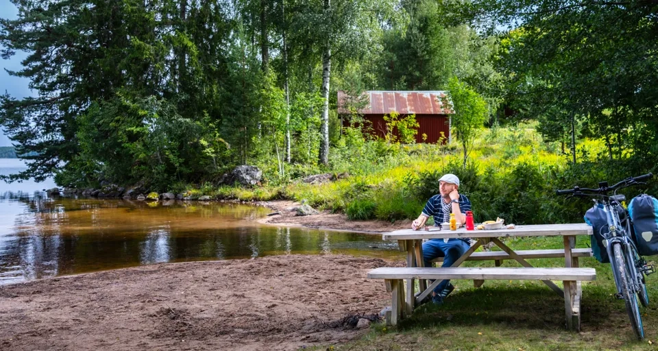 Cyklist vid en sjö i skogen.
