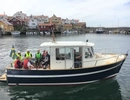 En grupp människor på båten Hoppet lever i Grundsunds hamn. 