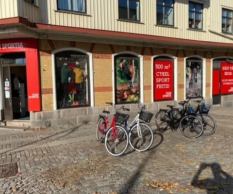 En grupp cyklar parkerade framför en byggnad.