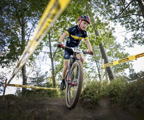 A man riding a bike down a dirt road.