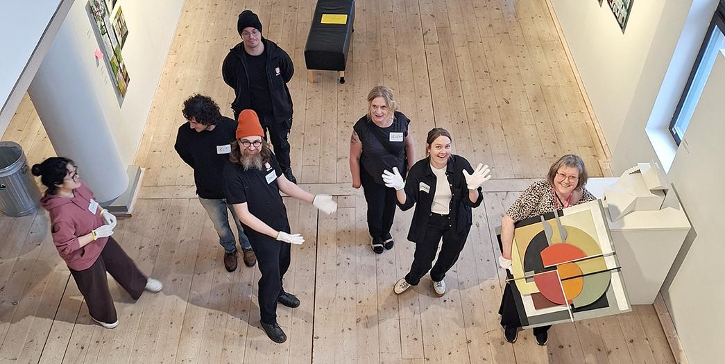 En grupp människor som står i en konstutställning.