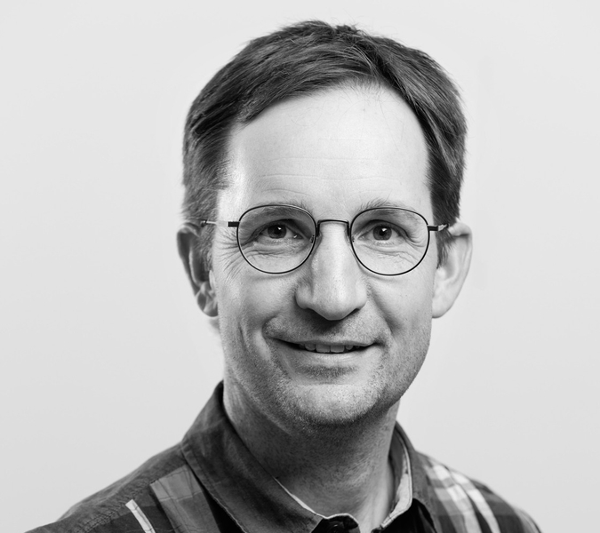 A black and white picture with a man with glasses.
