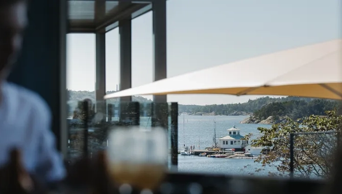 Människor som umgås i hotellmiljö med utsikt mot havet.