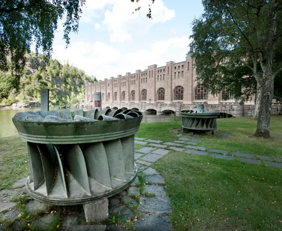 En turbin visas upp på en gräsmatta utanför Olidans vattenkraftstation.