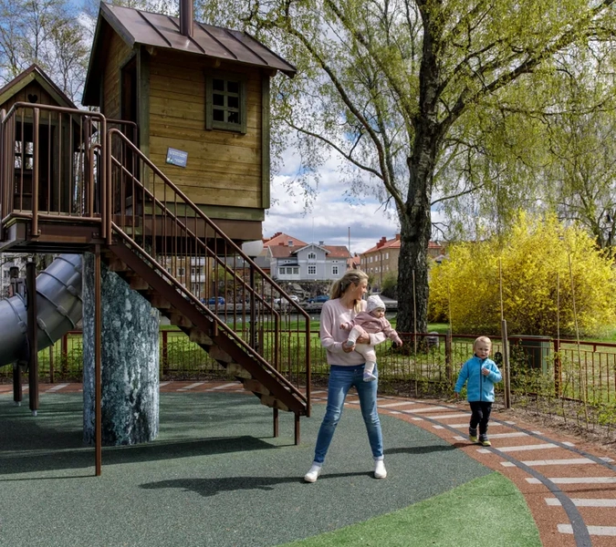 En kvinna och ett barn leker i en park.