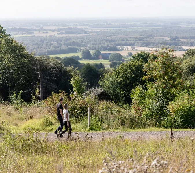 man och kvinna som vandrar på ett motionsspår. Vacker utsikt i bakgrunden.