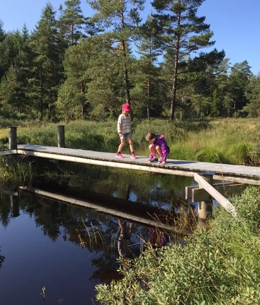 Två barn på en bro över ån vid vandringsleden vid Lidasjön
