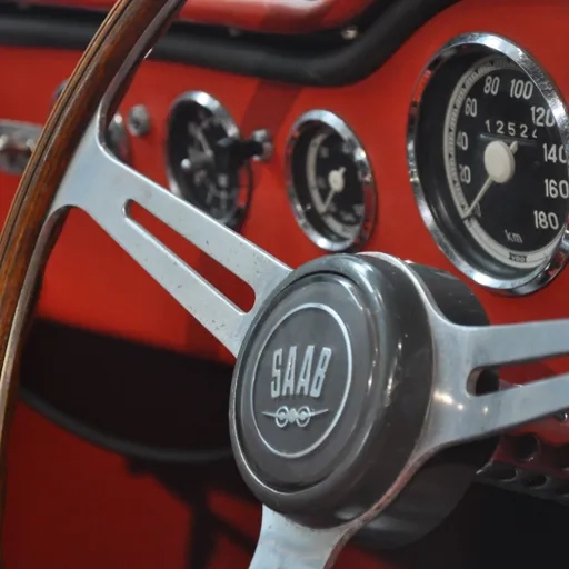 Närbild på en bilratt med Saabs logotyp