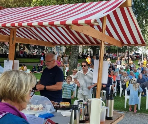 En folkmassa är samlad under ett tält.