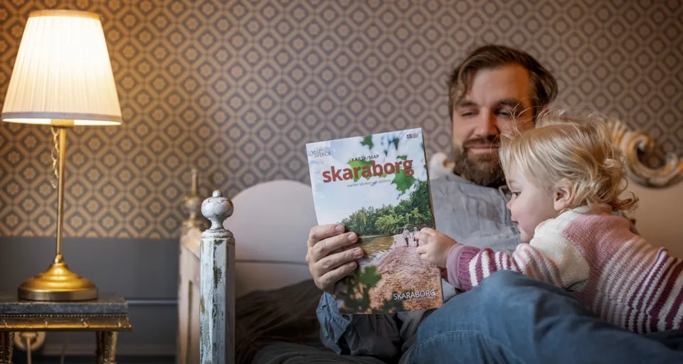 En man och ett barn i hotellmiljö.