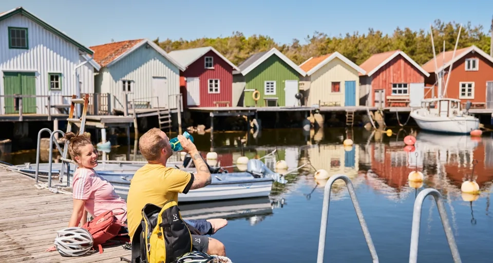 A couple of people sitting on a dock.