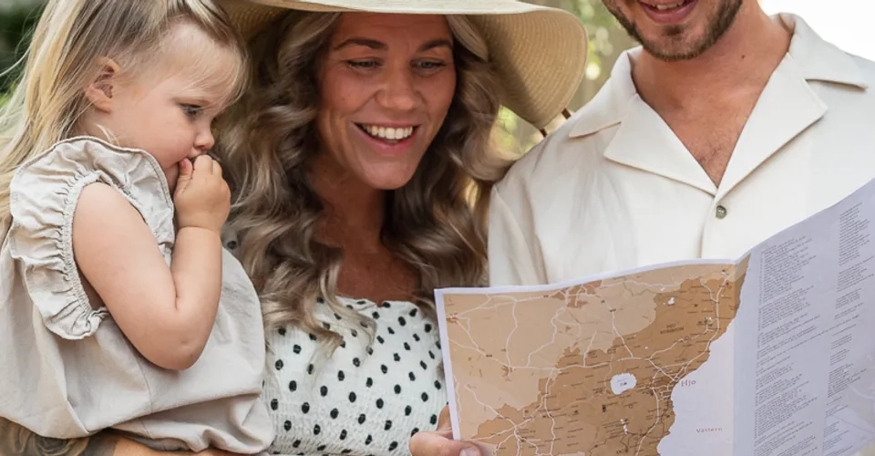 familj står och tittar på en karta på en gata i Hjo 