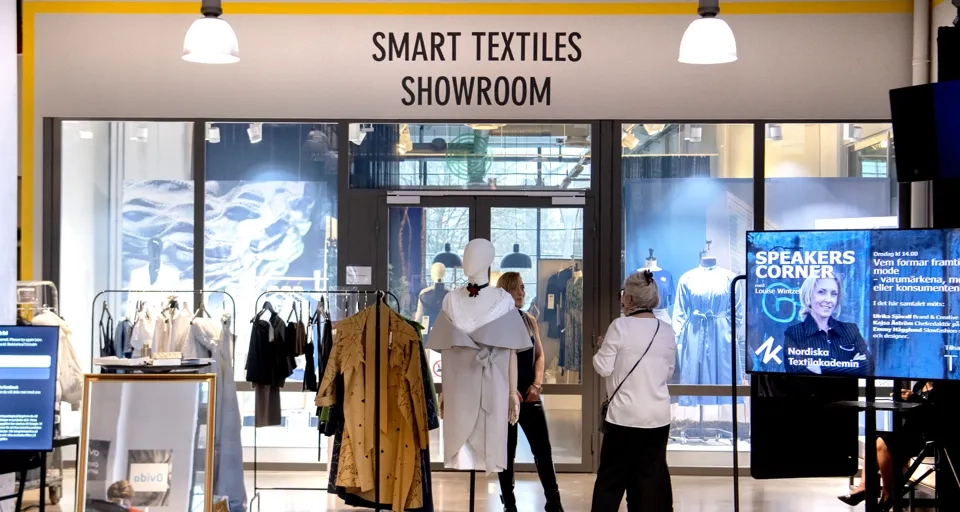En grupp människor som står framför Smart Textiles Showroom.