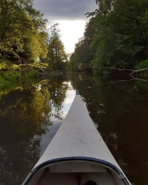 Kanot som glider fram i ån Flian