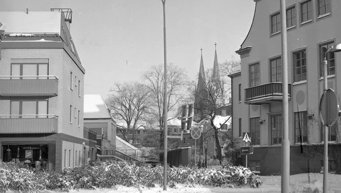 Två stora byggnader i ett snötäckt landskap vid en väg. Domkyrkans två torn syns i bakgrunden.