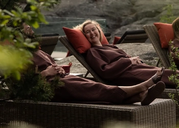 A woman laying on top of a couch next to a tree.