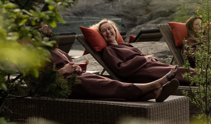 A woman laying on top of a couch next to a tree.