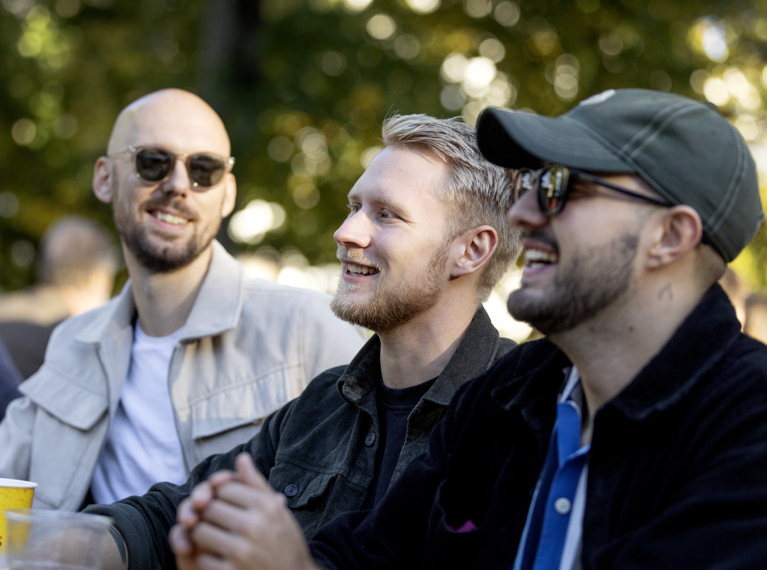 En grupp män som sitter runt ett träbord.