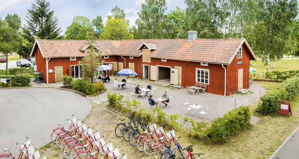 A group of bicycles parked in front of a red building.