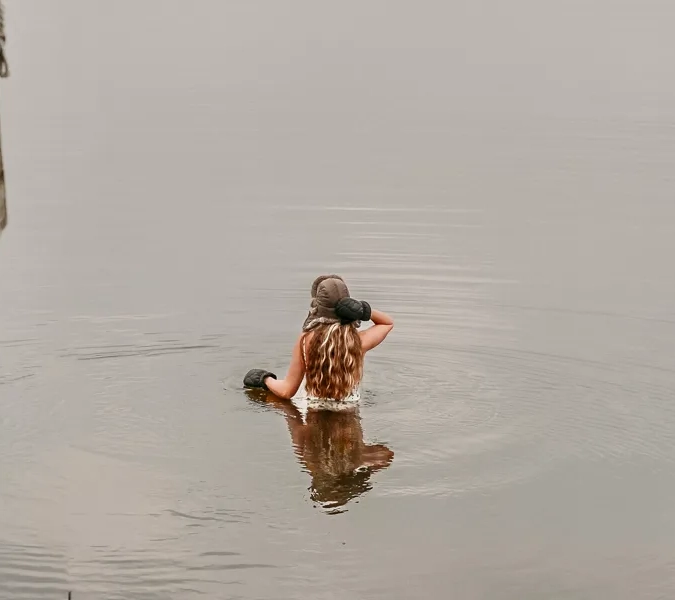 En person som simmar i ett vattendrag.