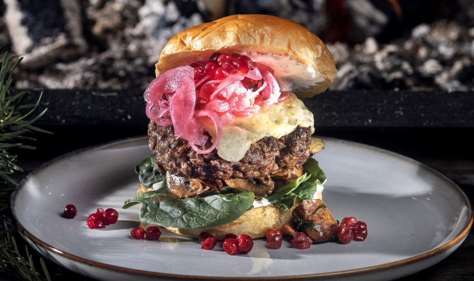 Viltburgare på tallrik framför öppen eld