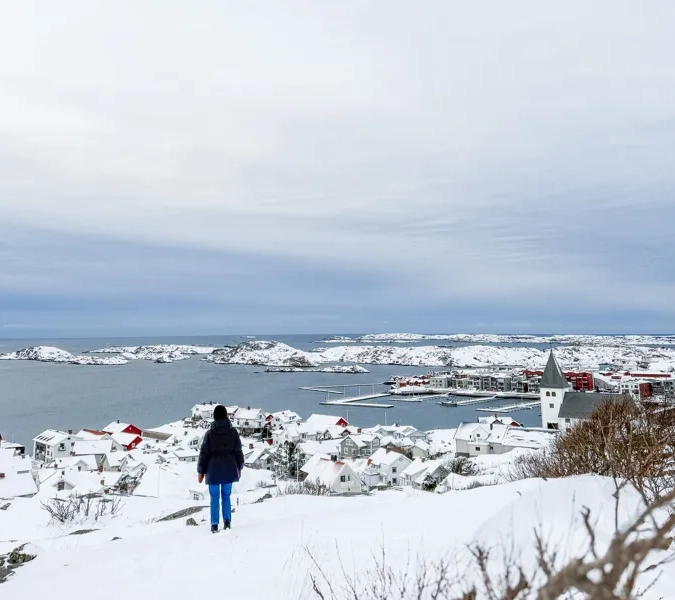 En person som står på toppen av en snötäckt sluttning.