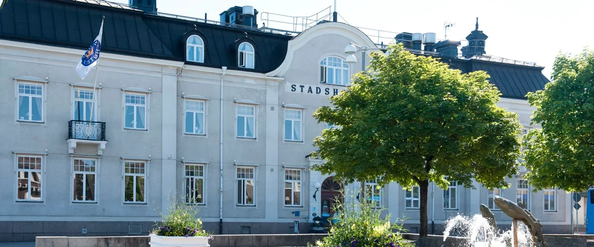 En stor byggnad med en fontän framför.
