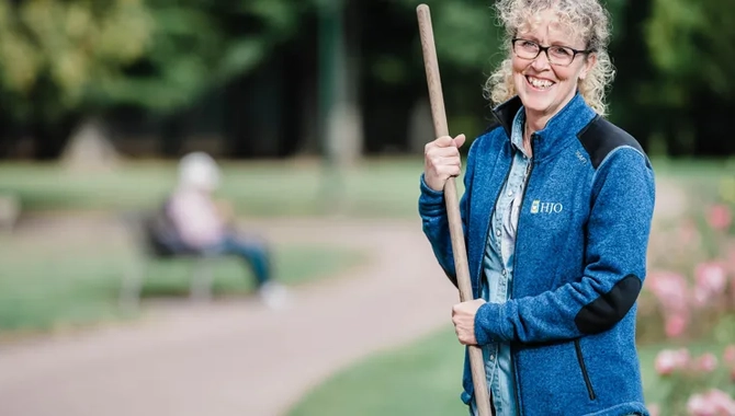 Eine Frau hält einen Stock in einem Park.