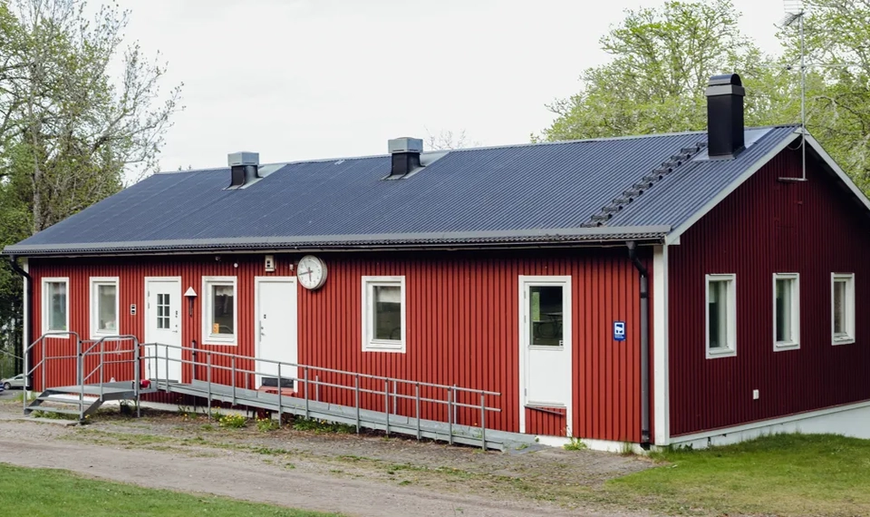 Hjobygdens orienteringsklubbs klubbstuga. En röd stuga med vita dörrar.