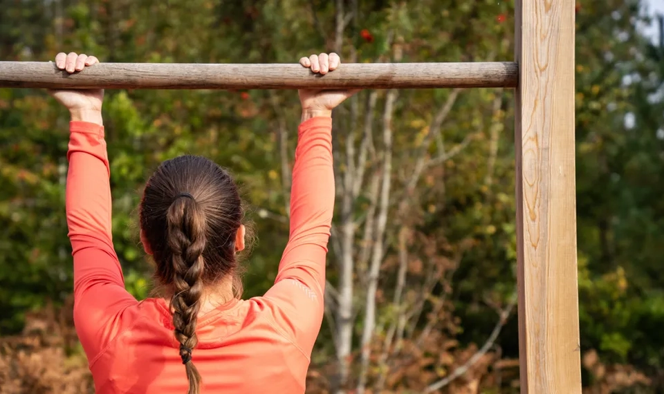 En kvinna som tränar vid av stationerna vid ett utegym