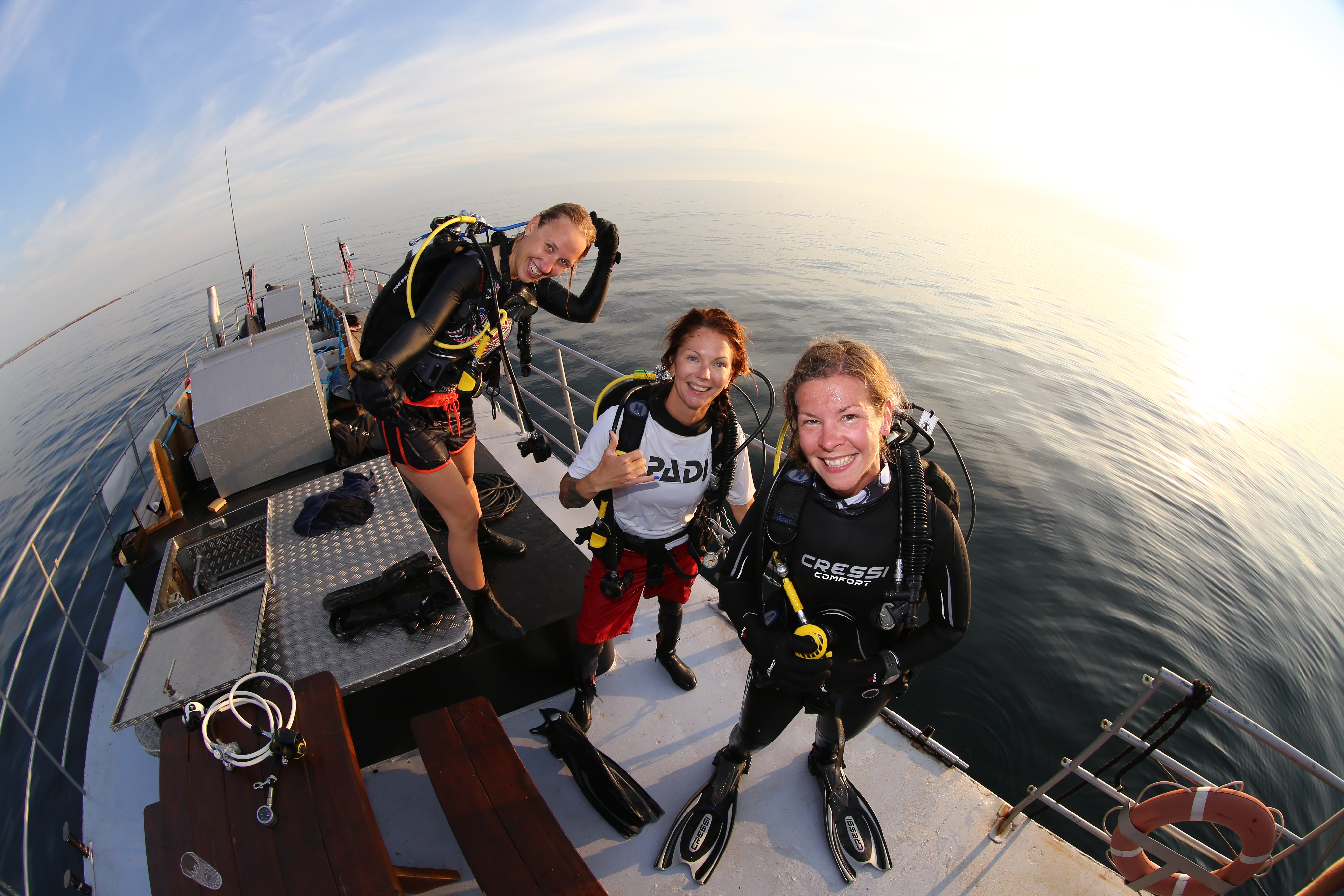 Three divers on a boat.