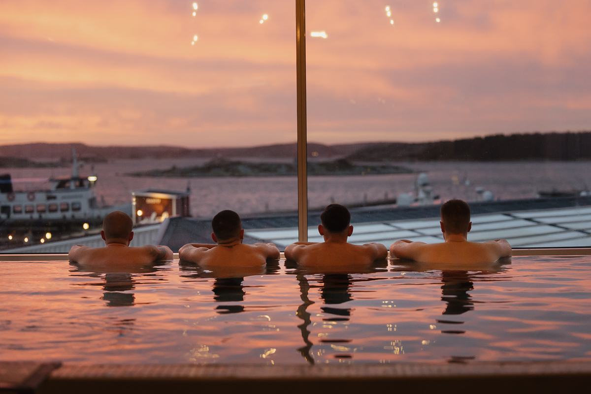 Male guests relaxing in an infinity pool at Tanumstrand