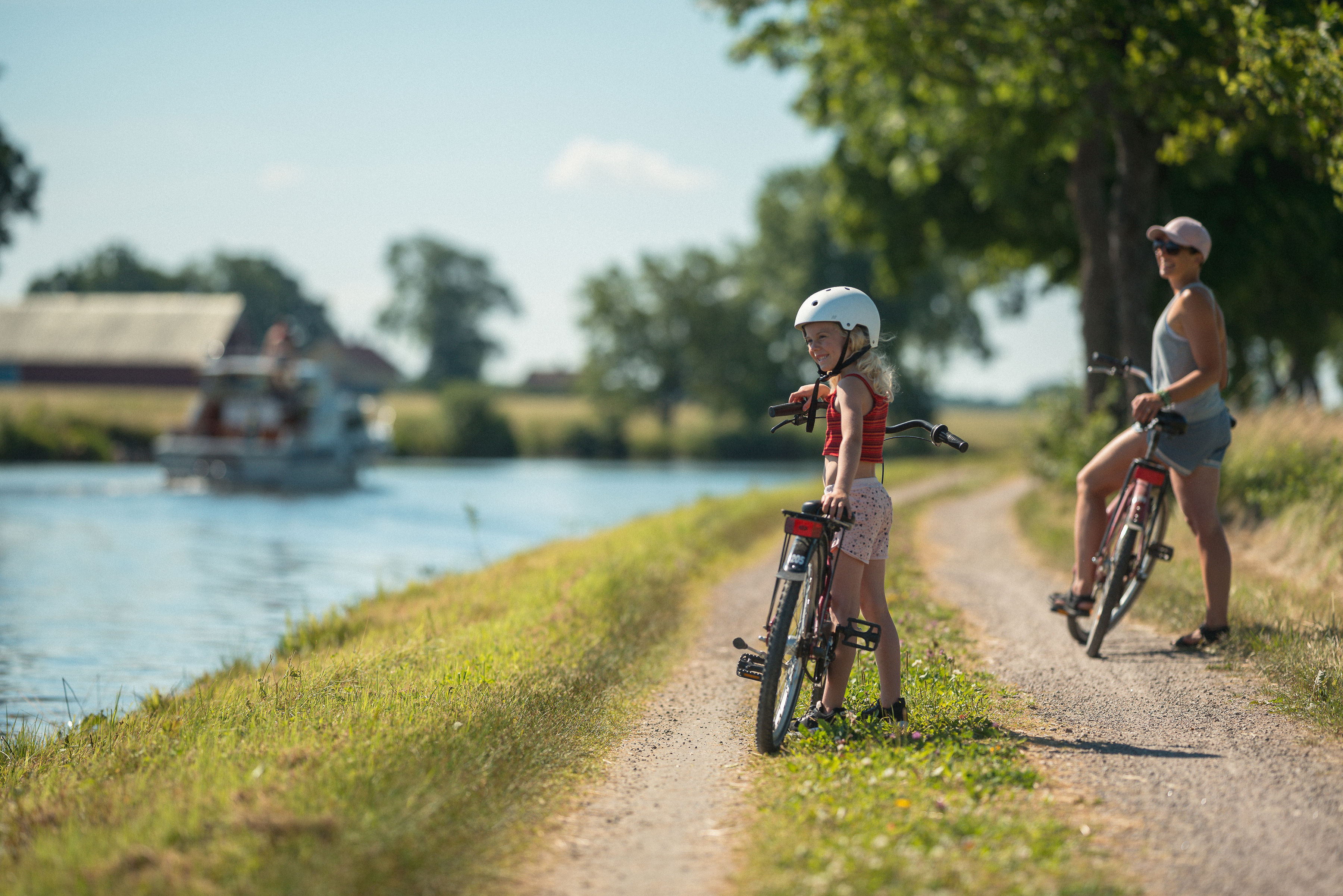 Barn med mamma cyklar utmed Göta kanal